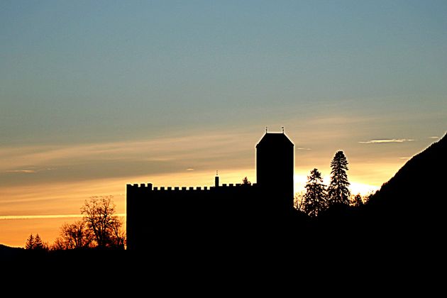 Farbenprächtiger Sonnenaufgang über dem Lienzer Schloss Bruck.
