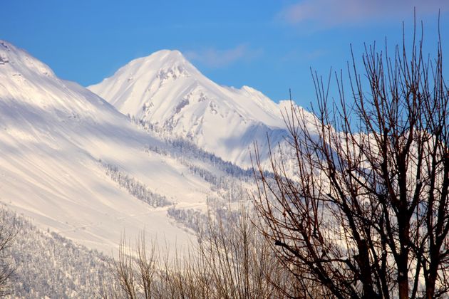 Blick vom Baggersee auf die verschneiten Berge.