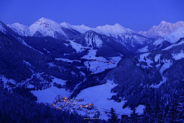 Das Berwanger Tal in Tirol, mit dem Blick in östliche Richtung zu den Gipfeln (von links) Kohlbergspitze, Hochschrutte, Daniel und ganz rechts die Zugspitze (2962 m). Unten der Ort Rinnen bei Berwang, mittig das Skigebiet der Bergbahnen Berwang vom Egghof Sunjet bis hinauf zur Heiterwanger Hochalm (1605 m).